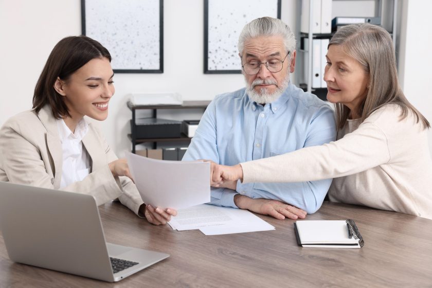 couple reviewing estate planning documents with a solicitor at home, representing life interest trusts and asset protection.